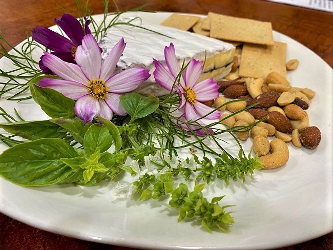 cheese platter with edible cosmos garnish
